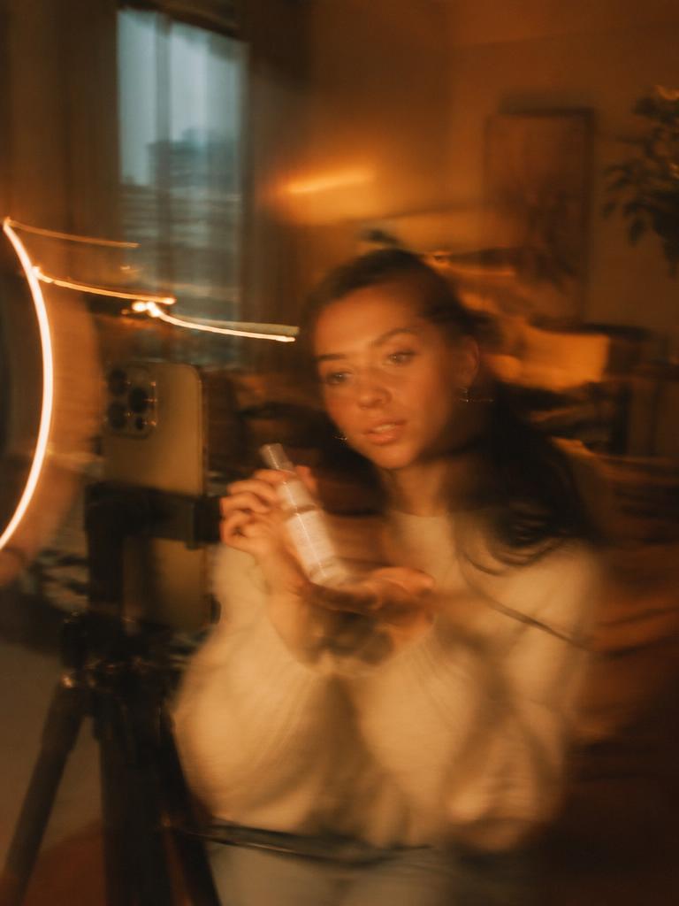 Creator holding a product up to her phone camera.